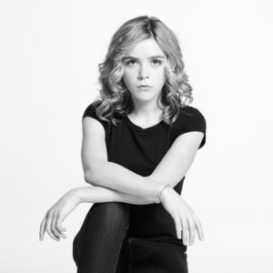 Kiernan Shipka by Timothy White, black and white portrait of the actress in black shirt and jeans