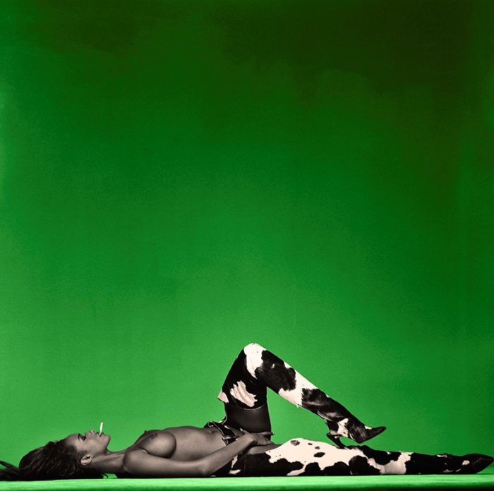 Iman Colour 1992 by Michel Comte Supermodel Iman lying on the floor wearing cow-print pants smoking a cigarette while touching herself