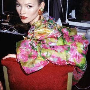 Kate Moss YSL Backstage by Roxanne Lowit, the model in pink and green flower dress, sitting in a red velvet chair