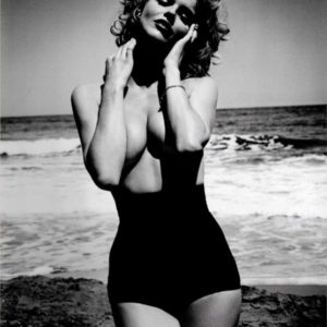 Eva Herzigova by Vincent Peters, the actress in black high waist swimtrunks at the beach