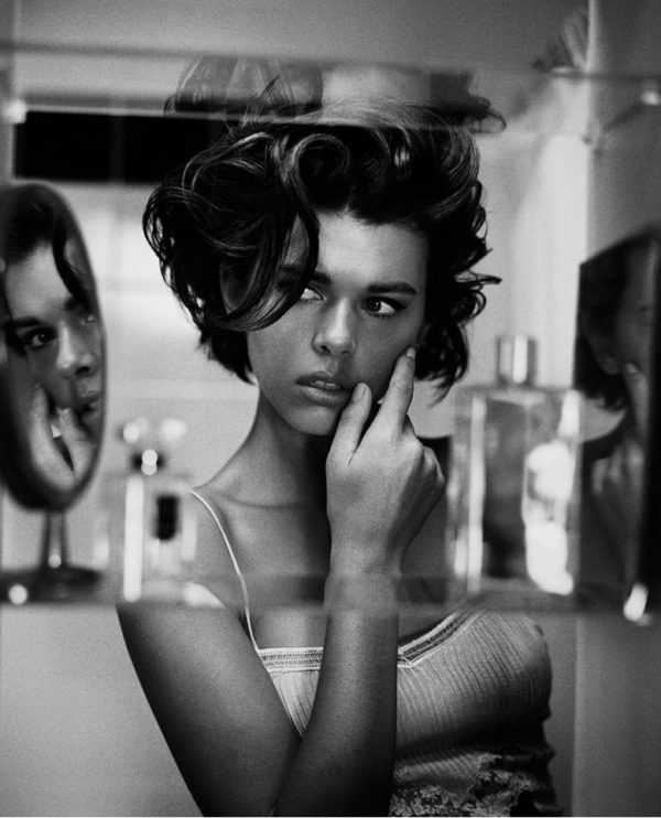 Georgia by Vincent Peters, a models reflection through a mirrored perfume shelf