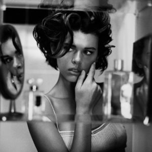 Georgia by Vincent Peters, a models reflection through a mirrored perfume shelf