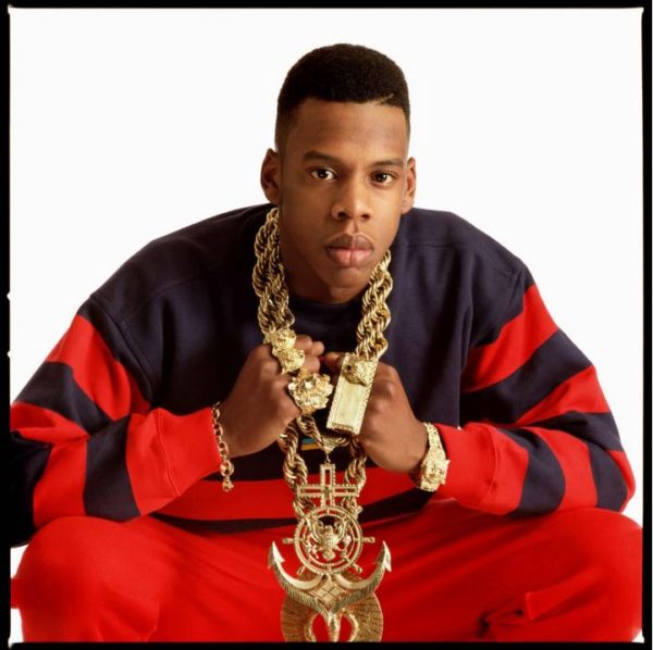Jay Z by Timothy white, color portrait of the rapper in blue and red jogger and big gold jewelery