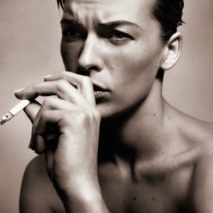 Mia Jovovich by Vincent Peters, the actress with short, slicked back hair smoking a cigarette