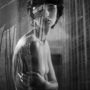 Milan 2019 by Vincent Peters, nude model looking through a glass full of waterdrops