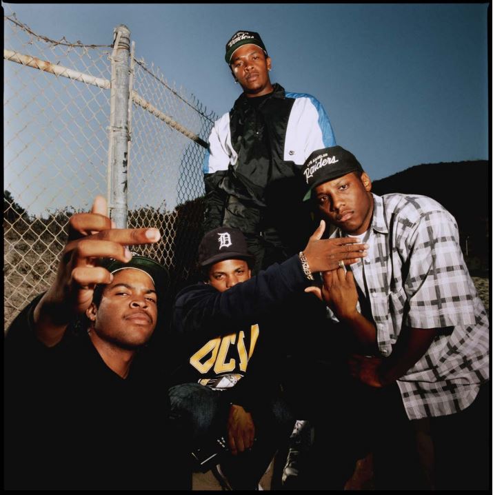 N.W.A. 1989 by Timothy Wihite, the Rappers in Caps posting next to a chain-link fence