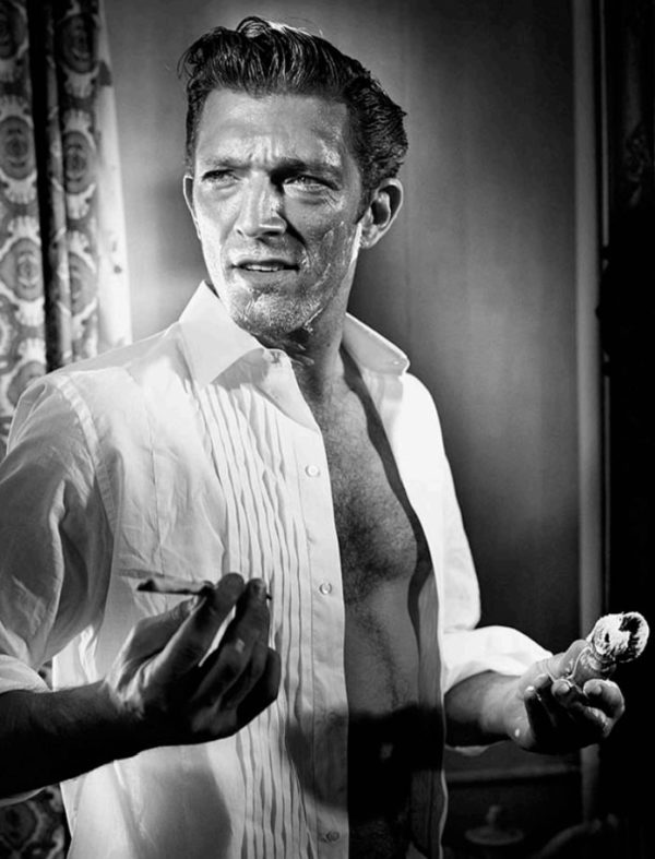 Vincent Cassel by Vincent Peters, black and white portrait of the actor in a white shirt while shaving