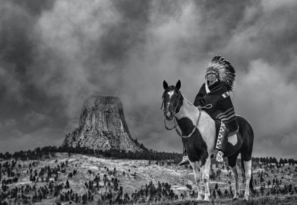 Chief by David Yarrow, Native Chieve with feather headpiece sitting on pinto horse