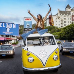 Summer of '75 in Colour by David Yarrow, Yellow VW Bus driven by Dog while a model with guitar is sitting on top
