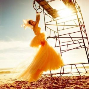 Beach by Kristian Schuller, Model in yellow dress and headpiece on rings at the beach