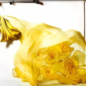Floating Dress by Kristian Schuller, model in flowing yellow dress hanging from a crane