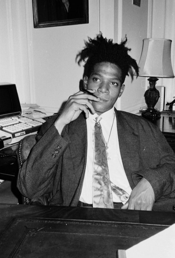 Jean Michel Basquiat by Roxanne Lowit, the artist in a suit and silk tie, smoking