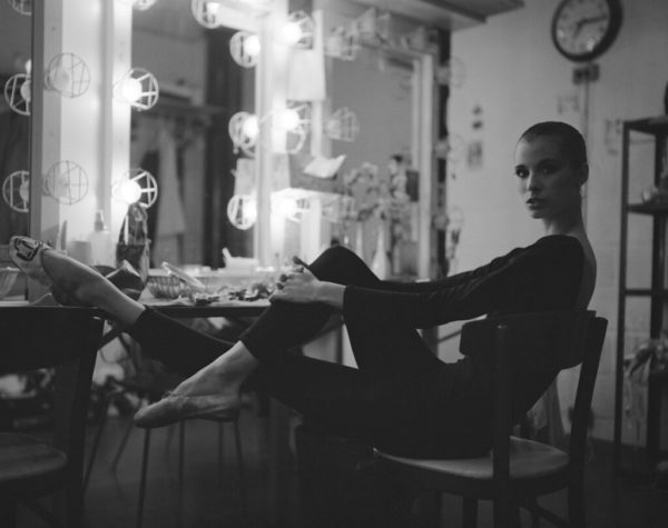 Wilhelmina Frankfurt, New York City Ballet 1979 by Arthur Elgort, ballerina in black leotard sitting backstage