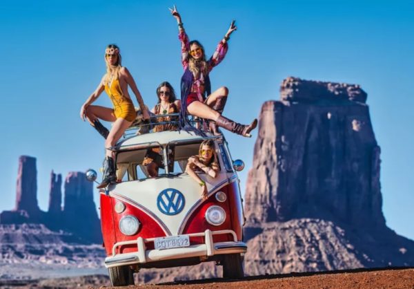 And the party never ends by David Yarrow red VW Bus with four girls in hippie clothing