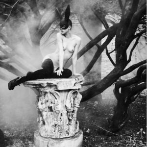 Bunny on a Pedestal by Ellen von Unwerth, Model in Bunnymask and stockings on broken stone table