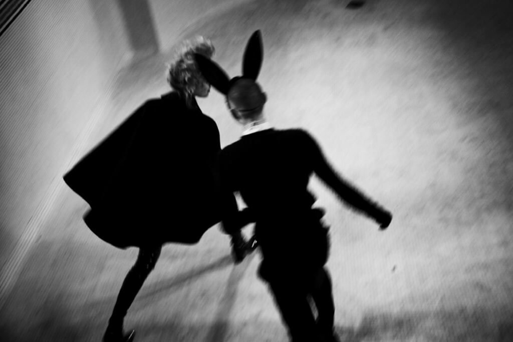 Bunny Run by Ellen von Unwerth, two figures in black, ne with bunny mask, running