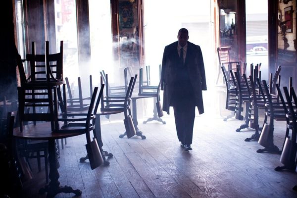 jay z new york by Arthur Elgort, the rapper in a suit walking in to a closed bar