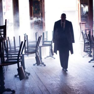 jay z new york by Arthur Elgort, the rapper in a suit walking in to a closed bar