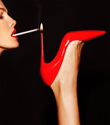 Super Slim by Tony Kelly, woman with red lip lighting a cigarette in the heel of a red shoe