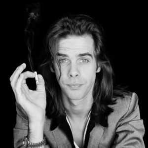 Nick Cave by Jesse Frohman, black and white Portrait of the Musician in grey suit, smoking