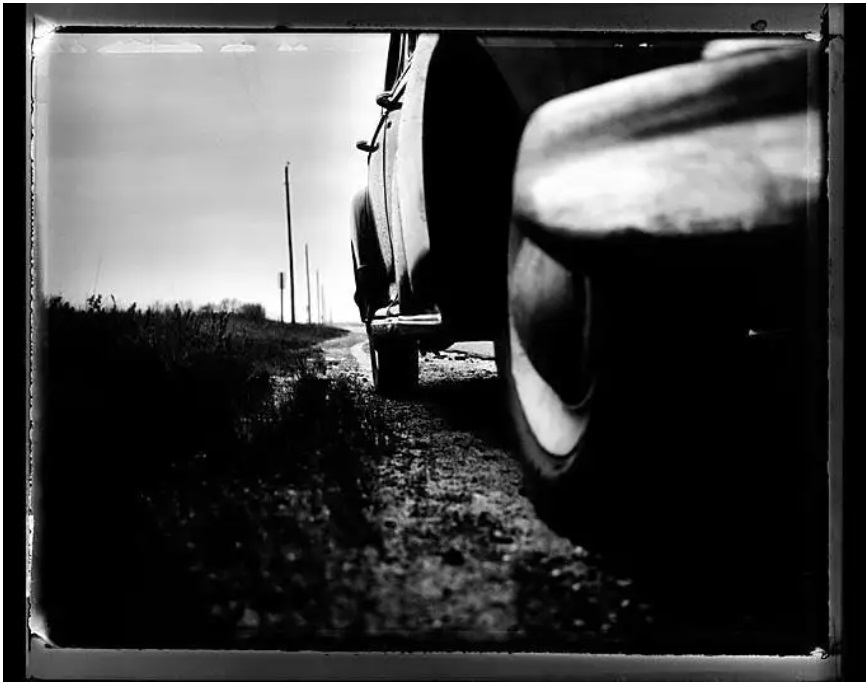 Timothy White, Car 37, black-and-white fine art print of car in close-up with landscape in the background
