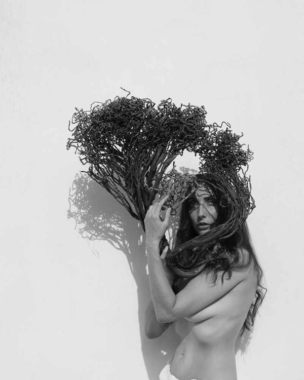 "Emma Two, 2023" by Sylvie Blum. Black-and-white fine art print of nude model holding weed
