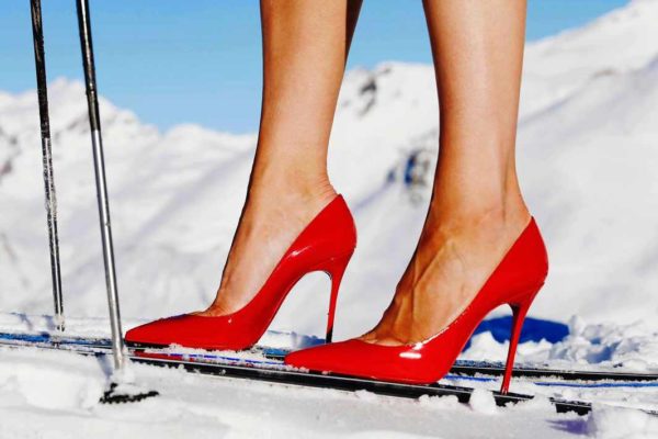 "Backcountry III" by Tony Kelly, colour photo print showing model wearing Louboutin heels on skiers with snow in background