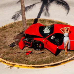 "Miami Car Crash, 2019" by Tony Kelly. Fine Art Print, colour, showing model in sparkly dress posing on top of crashed red car.