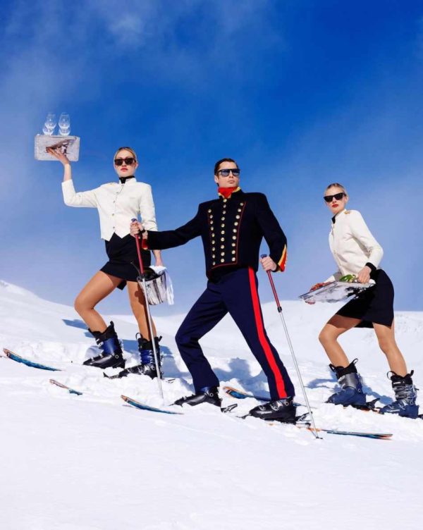 "Room Service" by Tony Kelly, Colour fine art print showing three staff with champagne on the slope wearing skiers