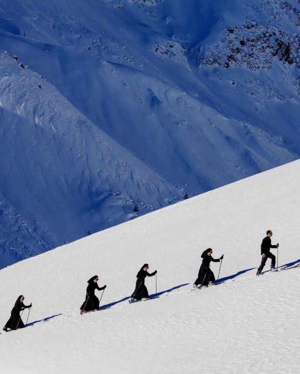 Saint Moritz St. Moritz Switzerland 2024 by Tony Kelly, a group of Nuns hiking up a snowy mountain with ski