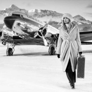 Winterwonderland 2023 by David Yarrow - Model in fur coat carrying a louis vuitton bag infront of a silver airplane
