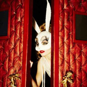 Peeking Bunny by Ellen von Unwerth - Model in White Bunny Mask looking through red cushioned door