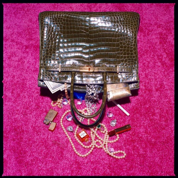 Shields, Birkin spill, luxury objects falling out of a birkin bag on a pink carpet