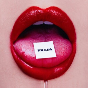 Shields, Prada Bubblegum, closeup of open mouth with red lipstick and a prada tag