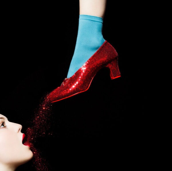 Shields, Ruby Slippers, wizzard of oz red shoe dripping red glitter into a womans mouth