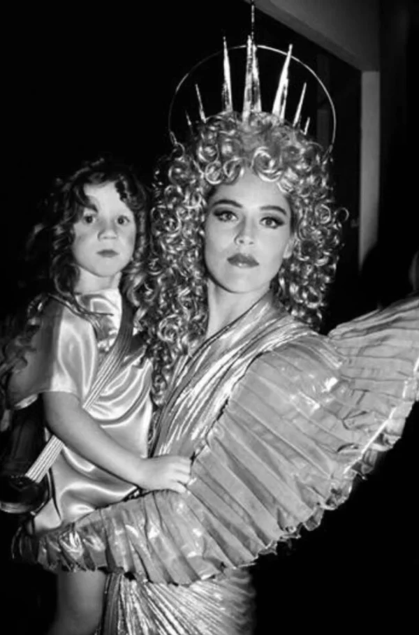 Sharon Stone Angel by Roxanne lowit, the actress in an angel costume holding a child