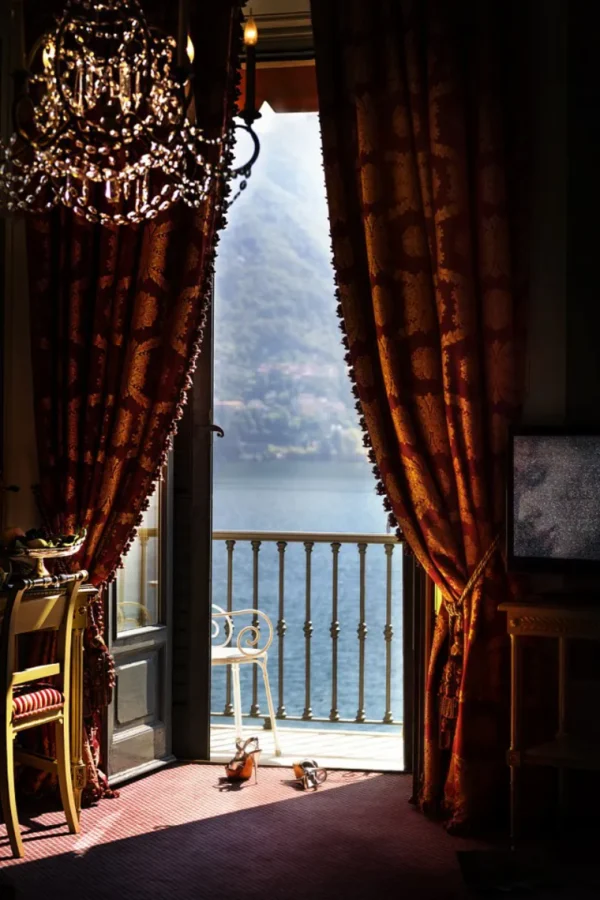 David Drebin, Lake View through balkony door with heavy red kurtains and chandelier, heels on the floor