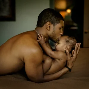 Famous Rapper Usher holding his newborn son by Timothy White