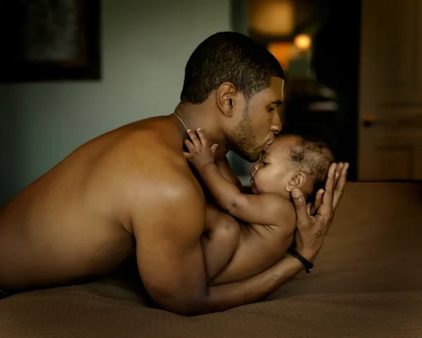 Famous Rapper Usher holding his newborn son by Timothy White